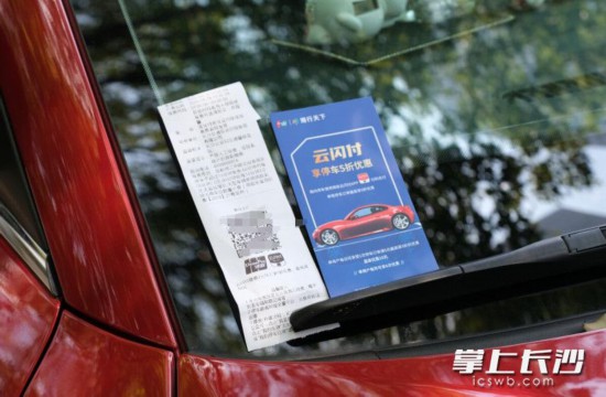 智能车位的管理人员将打印二维码和宣传卡放置在车辆上,引导车主支付。
